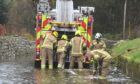 Firefighters pump water away from flooded Kingsfield Road in Kintore, near Inverurie