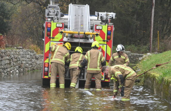 Firefighters pump water away from flooded Kingsfield Road in Kintore, near Inverurie