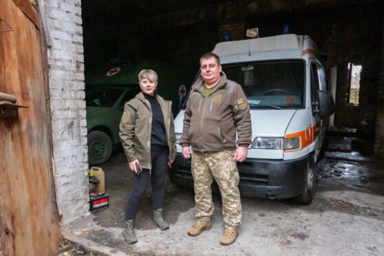 Volunteer Ivanna, left, and medic Zhenya with their ambulance in Donbas.