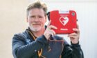 Former soldier Chris Wieczorek holding a defibrillator