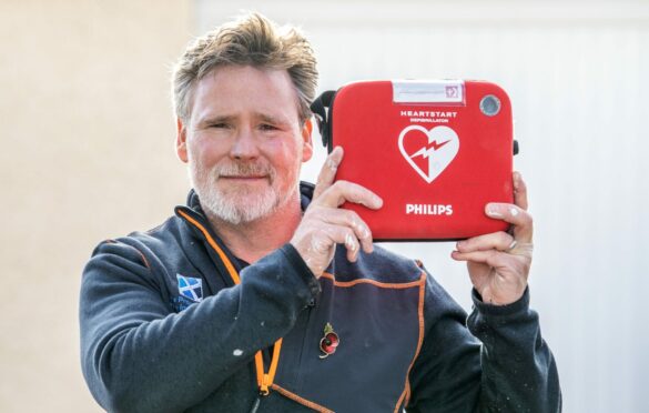 Former soldier Chris Wieczorek holding a defibrillator