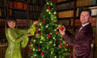 Pals Laura Boyd and Sean Batty add the finishing touches to the Christmas tree