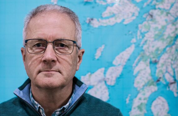 Rest and Be Thankful campaigner and former logistics expert John Gurr in front of a map of Argyll