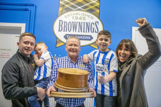 John Gall, with son Fraser and grandchildren Caden and Rory, is presented with the World’s Best Scotch Pie Award 2022 by Carol Smillie