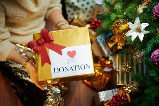 A woman donating Christmas gifts for charity.