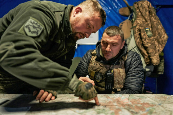 Ukrainian soldiers look at a map in an underground command centre in Bakhmut, Donetsk region, on Christmas Day