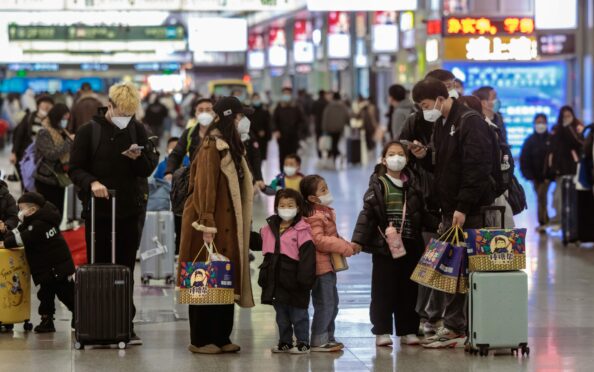 A family on the move at the railway station in Shanghai yesterday as millions of people travel back to their home towns as the Chinese New Year begins