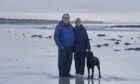 Dave MacKay and wife Morag walk on the beach near their island croft on Benbecula