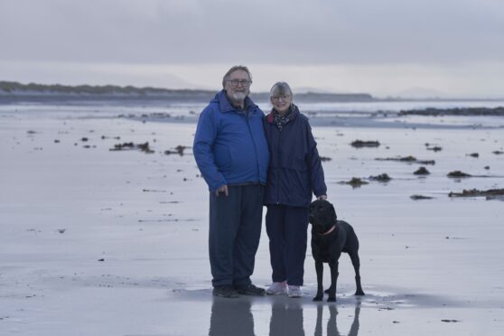 Dave MacKay and wife Morag walk on the beach near their island croft on Benbecula