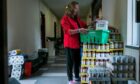 Foodbank volunteer Ingrid Mitchell prepares grocery packages for families in need at St Gregory’s Church, Glasgow.