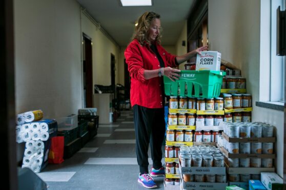 Foodbank volunteer Ingrid Mitchell prepares grocery packages for families in need at St Gregory’s Church, Glasgow.