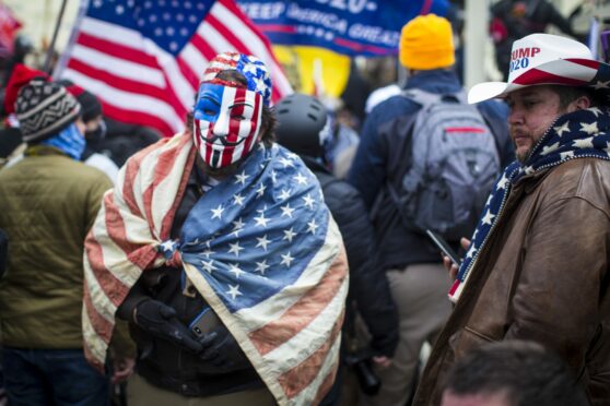 A Trump supporter wears a painted American flag Guy Fawkes mask during the January 6 riots in  Washington DC