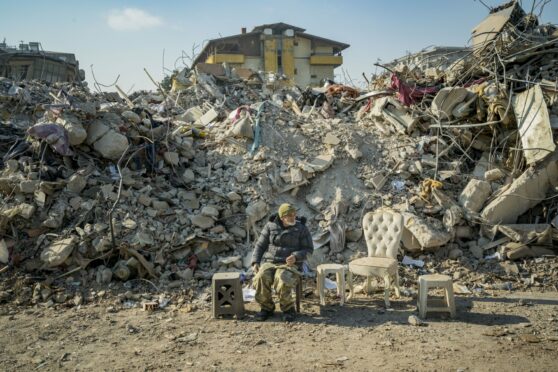 A man guards the ruins of his destroyed apartment buildings in Antakya on Monday after the massive earthquake which hit southern Turkey and Syria.