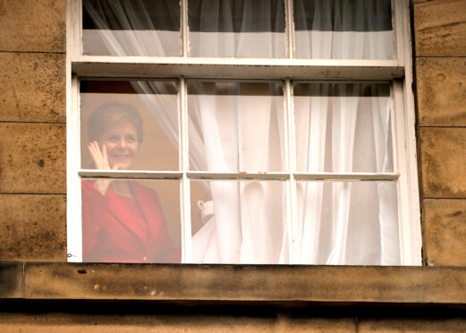 First Minister Nicola Sturgeon waves to members of the public outside Bute House in Edinburgh after she announced during a press conference that she will stand down as First Minister