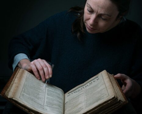 Conservator Keira McKee undertakes delicate repair work to the Shakespeare First Folio at Glasgow University