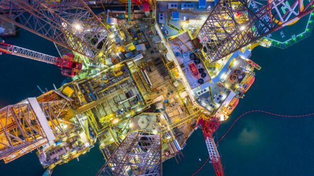 An aerial view of an offshore oil rig drilling platform at night