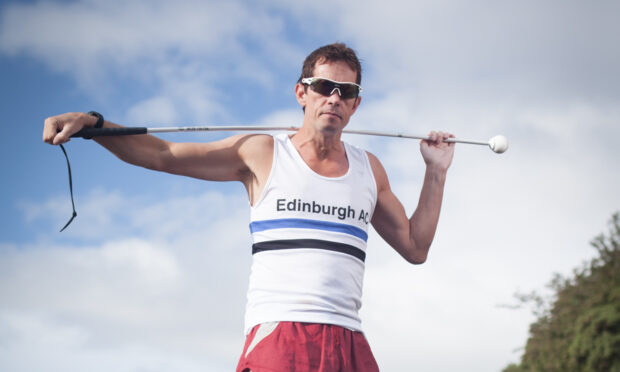 A photo of blind marathon runner Steven Waterston with a white cane.