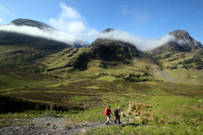 Hillwalkers set out towards the Three Sisters mountain range in Glencoe