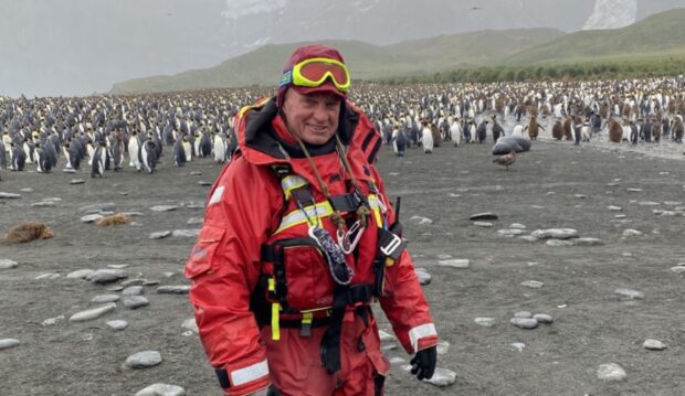 Polar tour guide Bill Smith p-p-p-poses with penguins