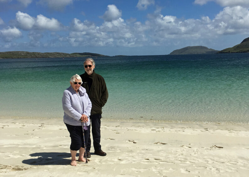 A photo of a couple on a beach in the Outer Hebrides