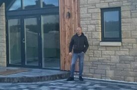 A photo of self-builder Mark outside his new home