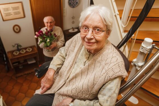 Elderly woman uses stairlift. She has increased freedom of movement in her home.