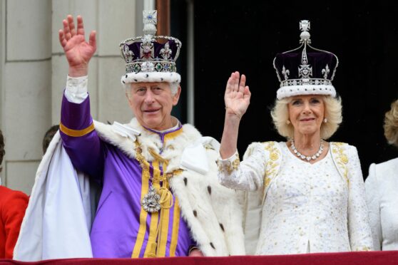 King Charles III and Queen Camilla wave to well-wishers from the palace balcony