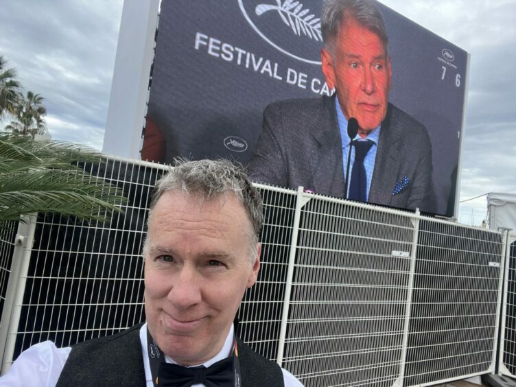 John MacLaverty at Cannes, posing in front of Harrison Ford on the big screen