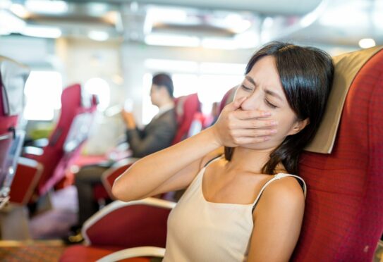 Woman on plane with travel sickness