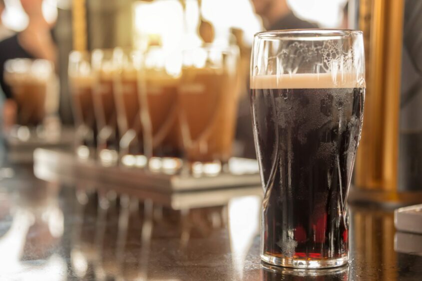 Close up of a glass of stout beer on a bar