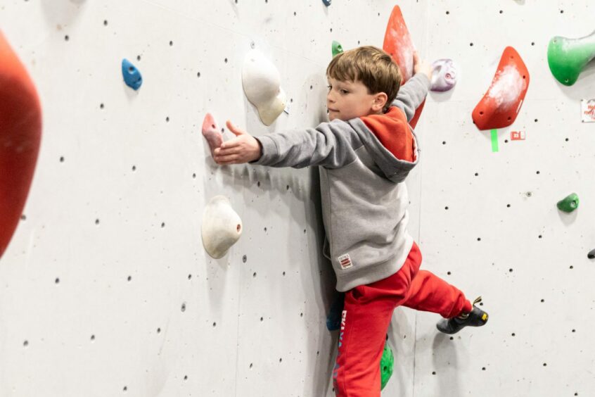 A boy doing some indoor climbing