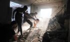 Palestinians try to rescue survivors from the rubble of a building following an Israeli strike in Khan Yunis in the southern Gaza Strip.