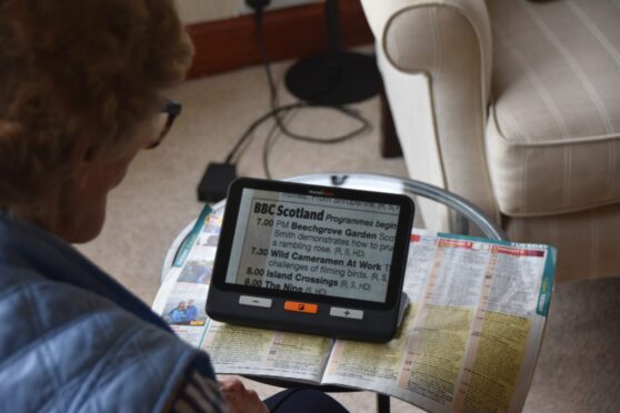 a veteran copes with losing eyesight by using a tablet / technology that helps her to read