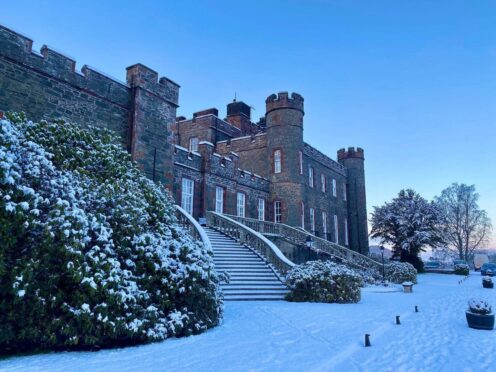 Stobo Castle exterior in the snow and evening twilight.