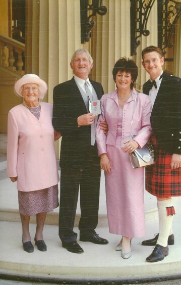 Gus with his family as his father picked up an MBE.
