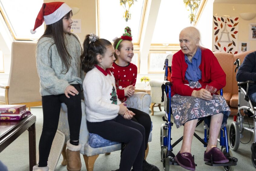 The children chat to resident Margaret Houston about Christmas.