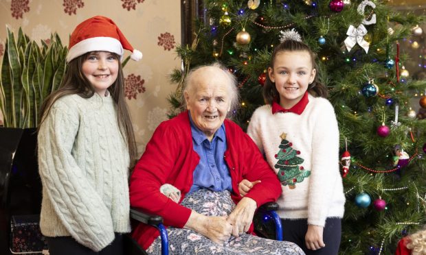 Margaret Houston with Ayla McGeogh, left, and Casey McConville beside the Christmas tree at Rashielee Care Home in Erskine.