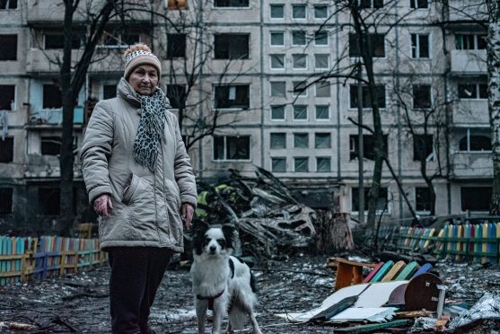 Valentina Khomenko walks her dog through the bombed block of flats in Kyiv’s Dniprovs’kyi district.