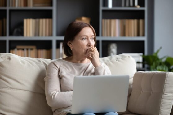 Woman mulling over choices in front of computer.