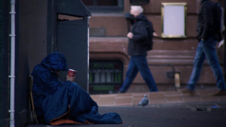 Homeless man tries to keep warm.