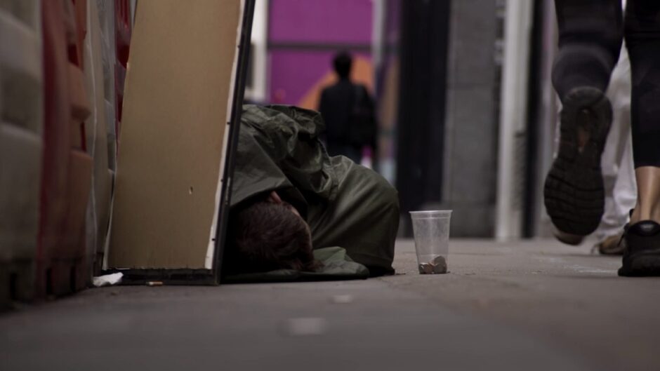 A homeless man sleeping on the street.
