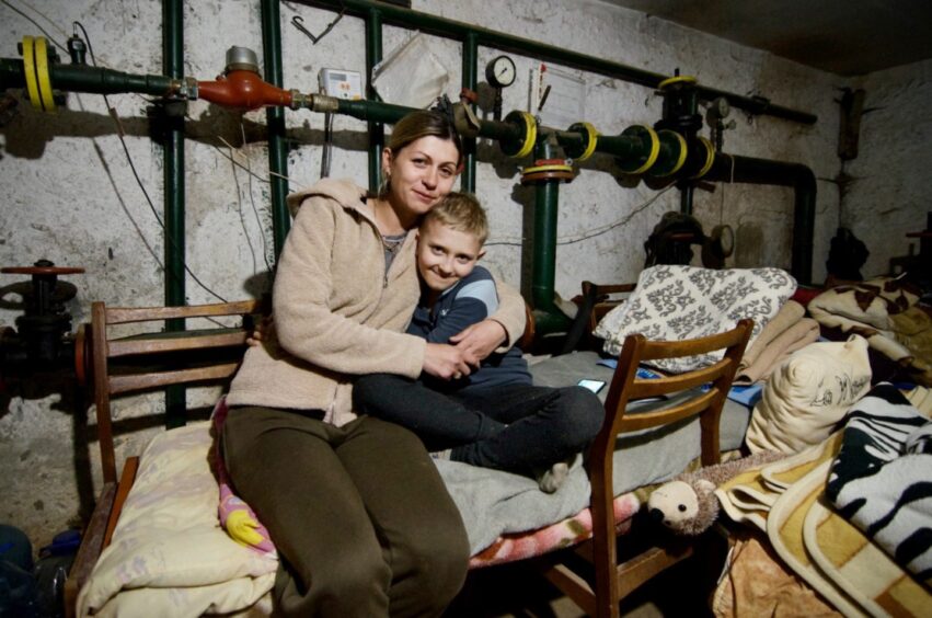 Misha and her son Yulia sheltering in the basement of their apartment building in 2022.