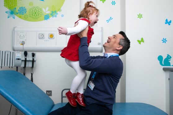 Georgia is all smiles as she is reunited with neurosurgeon Roddy O’Kane, who saved the toddler’s life.