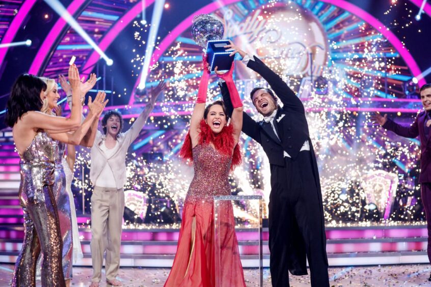 Ellie Leach and Vito Coppola lift the famous Strictly glitterball trophy.