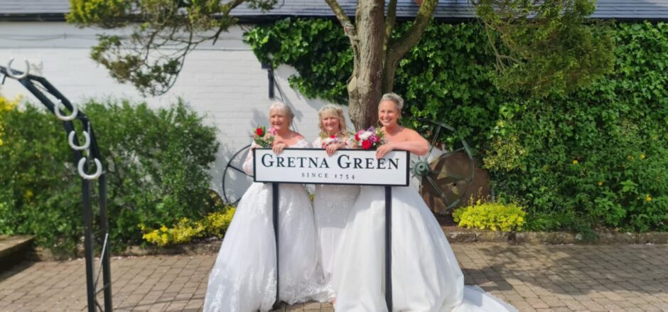 All smiles at the Gretna Green signpost.