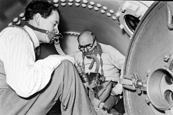 JBS Haldane (right) wearing breathing apparatuses inside the smallest Siebe Gorman chamber during his experiments.