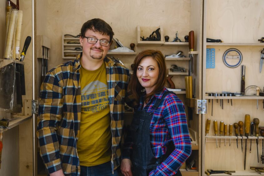 Adam and Vanessa posing in front of the tools.