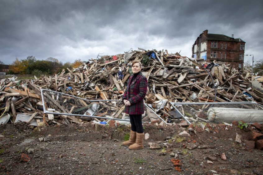 Margaret Jaconelli stands outside the remains of her home. In 2011, she was forcibly evicted by police and sheriff officers.