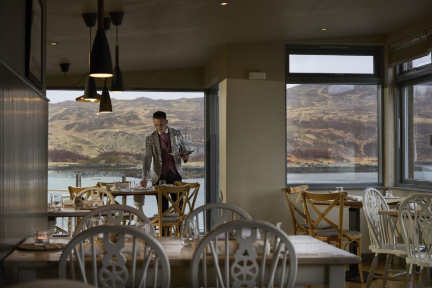 Waiter setting table at Kylesku restaurant.