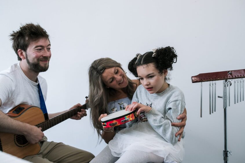 Kia with mum Steph and therapist Reuben during a therapy session.